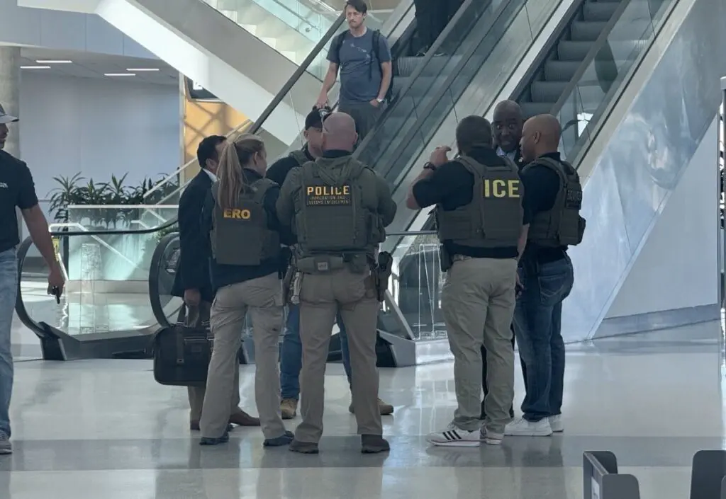Agentes del Ice hablando al pie de escalera eléctrica