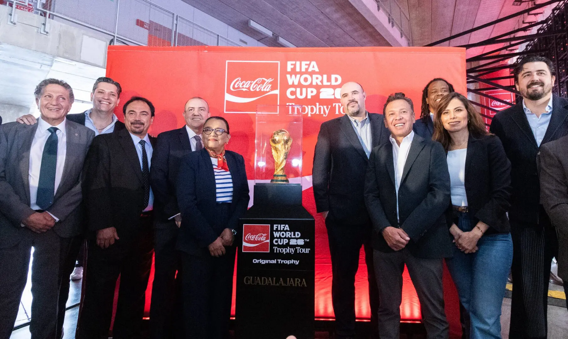 Funcionarios en evento con copa FIFA.