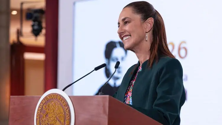 Claudia Sheinbaum sonríe frente a micrófono en Palacio Nacional