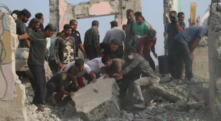 Hombres en Irán levantando escombros.