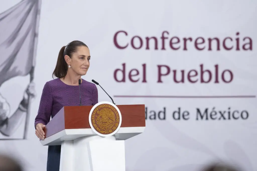 Woman speaking at podium with Mexican seal