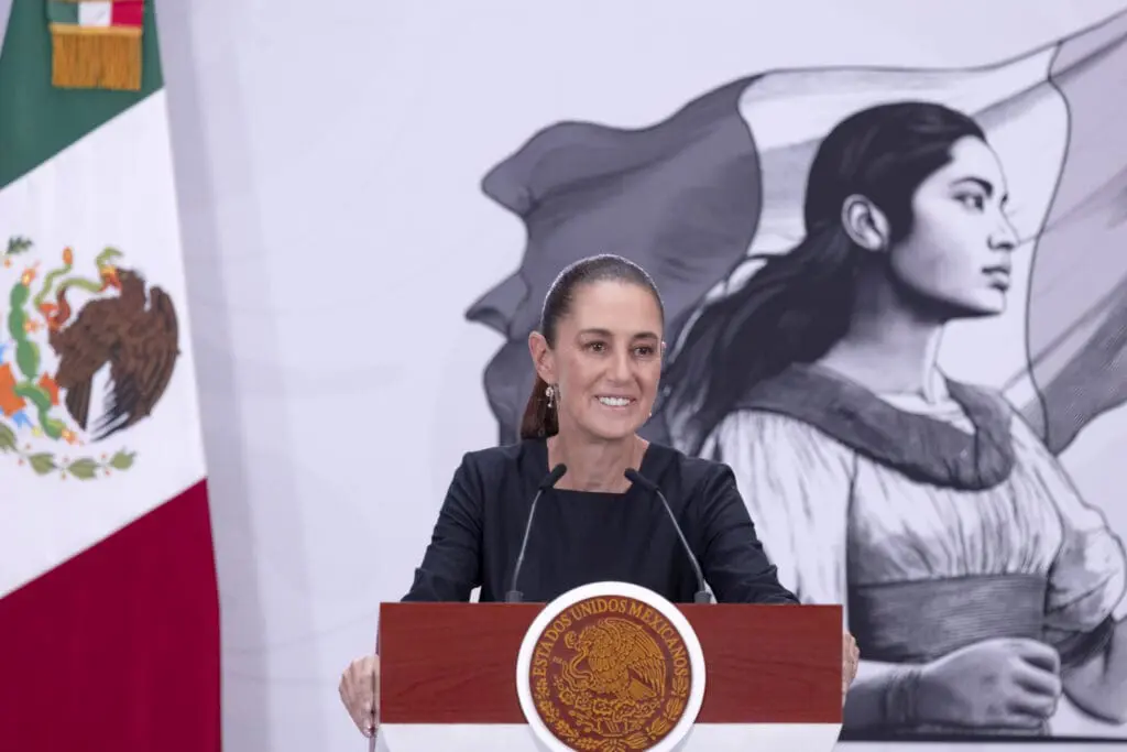 Smiling presenter at podium with national crest