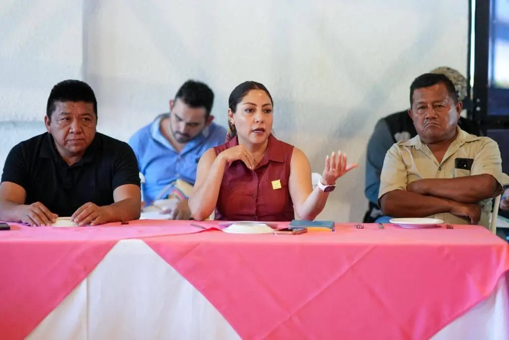 Woman speaking between two men at table