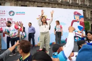 Clara Brugada alzando las manos en evento