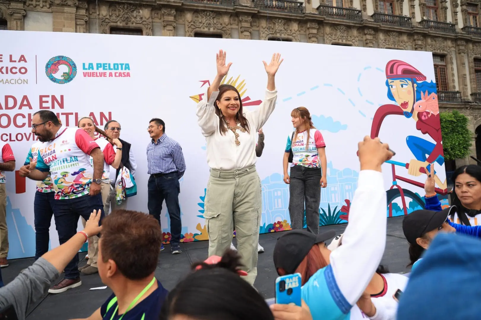 Clara Brugada alzando las manos en evento