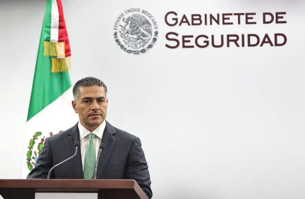 Person at podium with Mexican flag backdrop