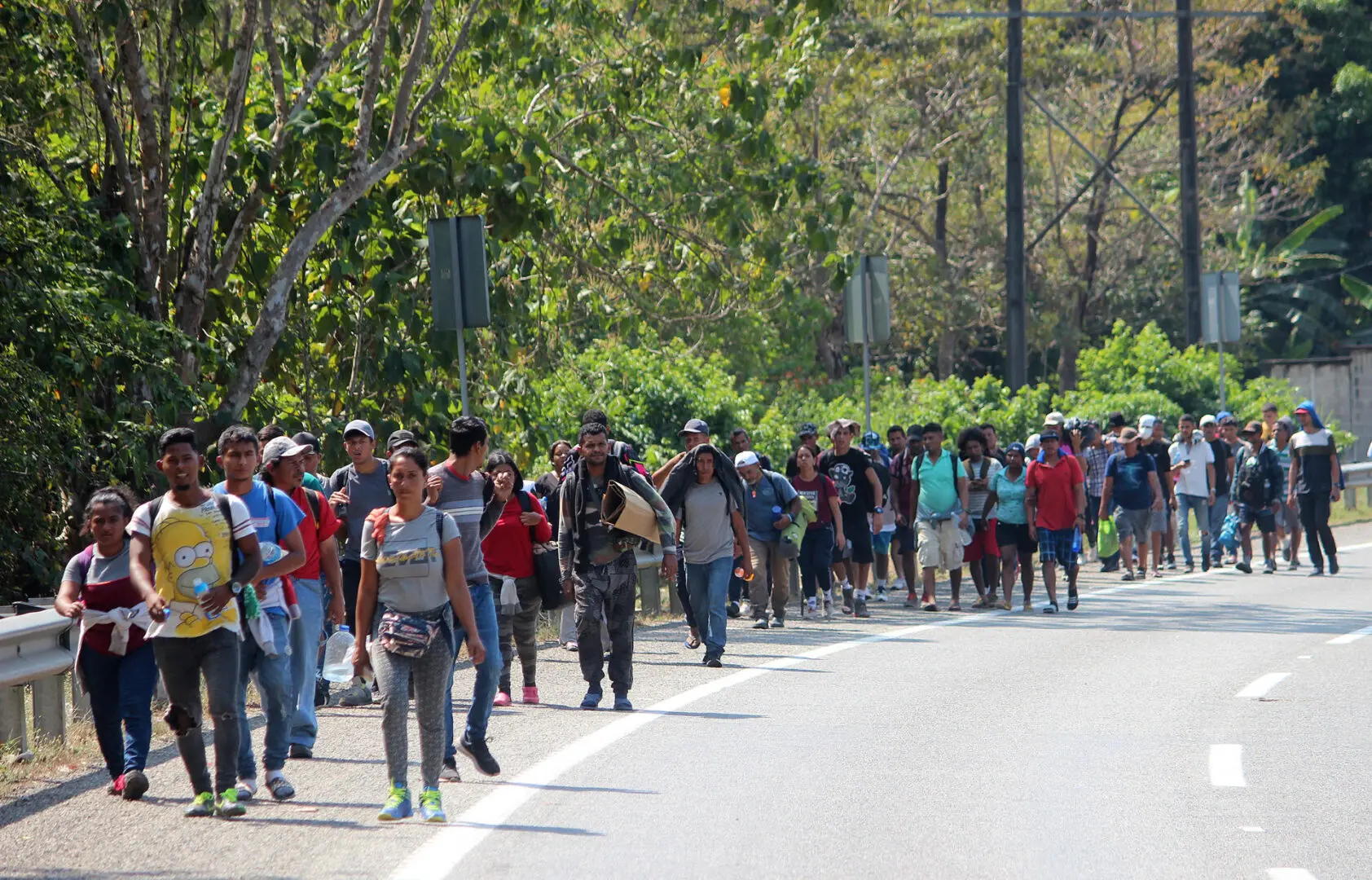 Migrantes en caravana caminan en vía de Chiapas