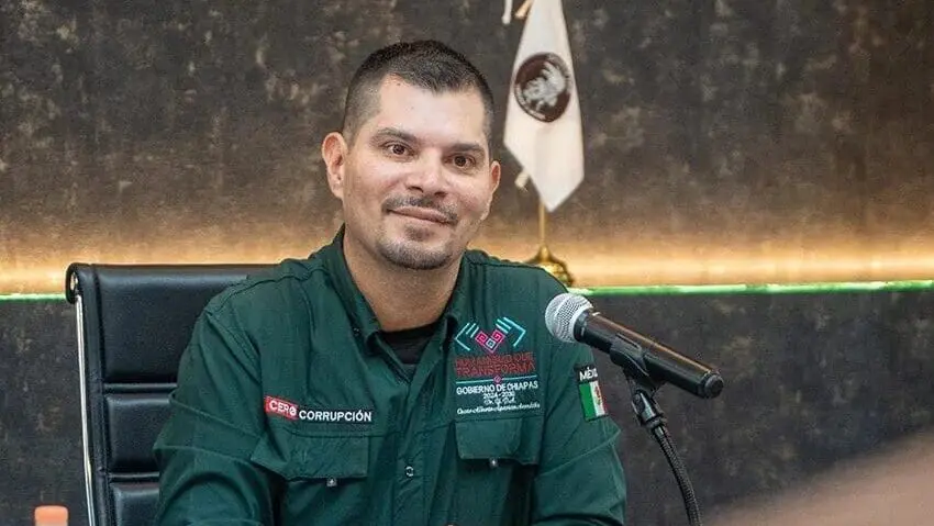 Man in green uniform speaking at microphone