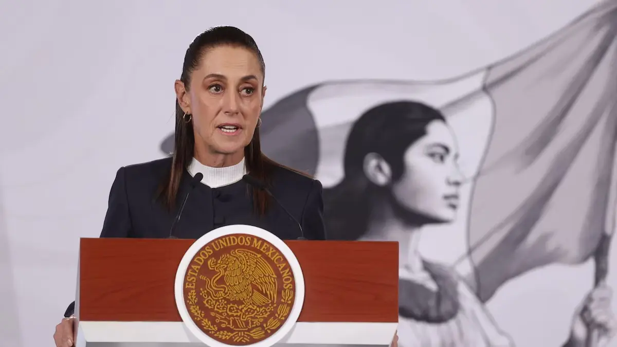 Woman speaking at podium with Mexican emblem
