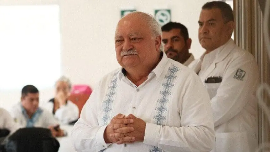 Elderly man in white shirt addressing group