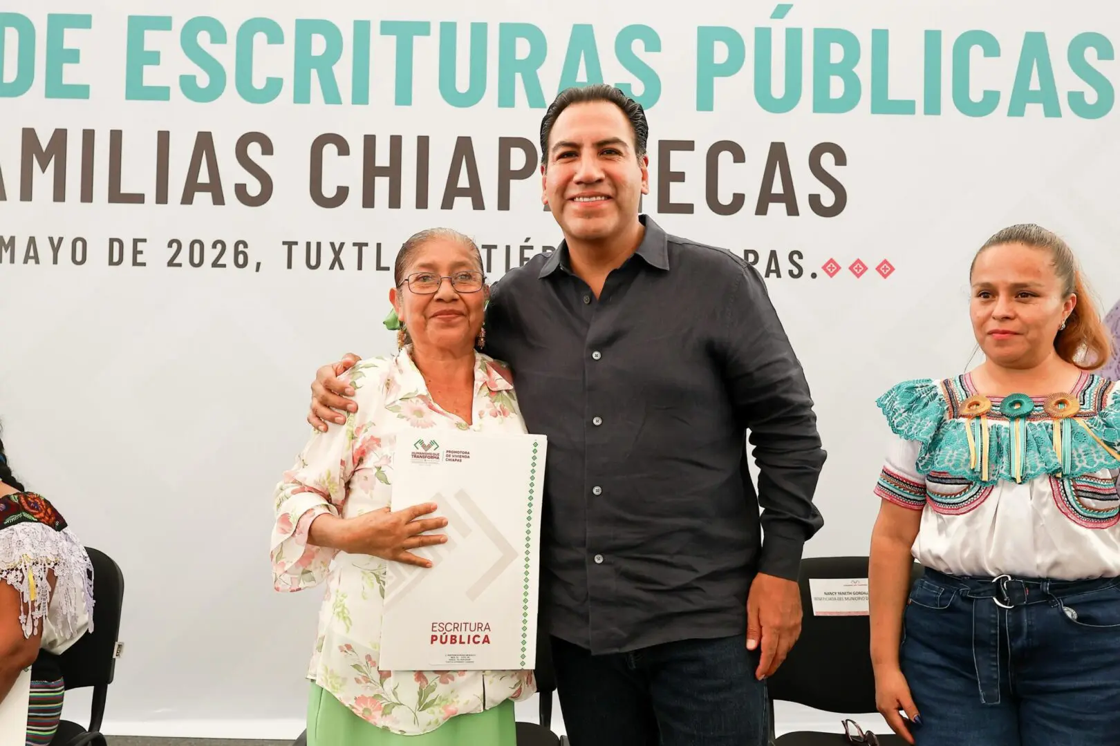 Man embracing woman holding certificate at ceremony