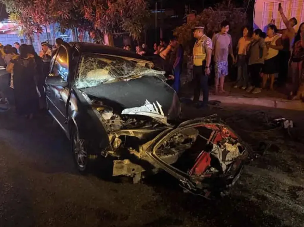 Heavily damaged car crash scene at night