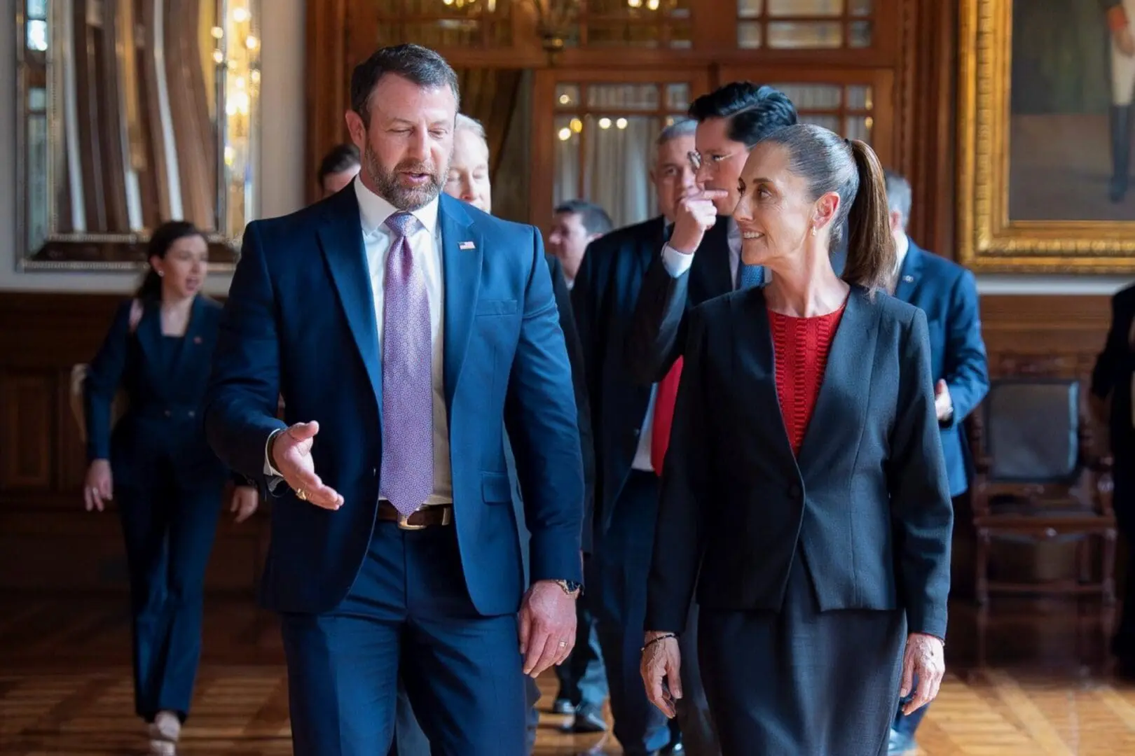 Group of formally dressed people walking through hallway