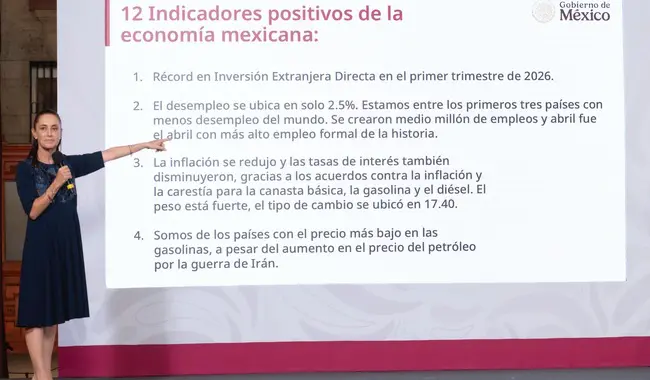 Presenter pointing at slide listing Mexico's economic indicators