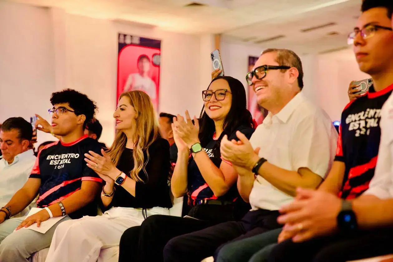 Smiling audience clapping at indoor event