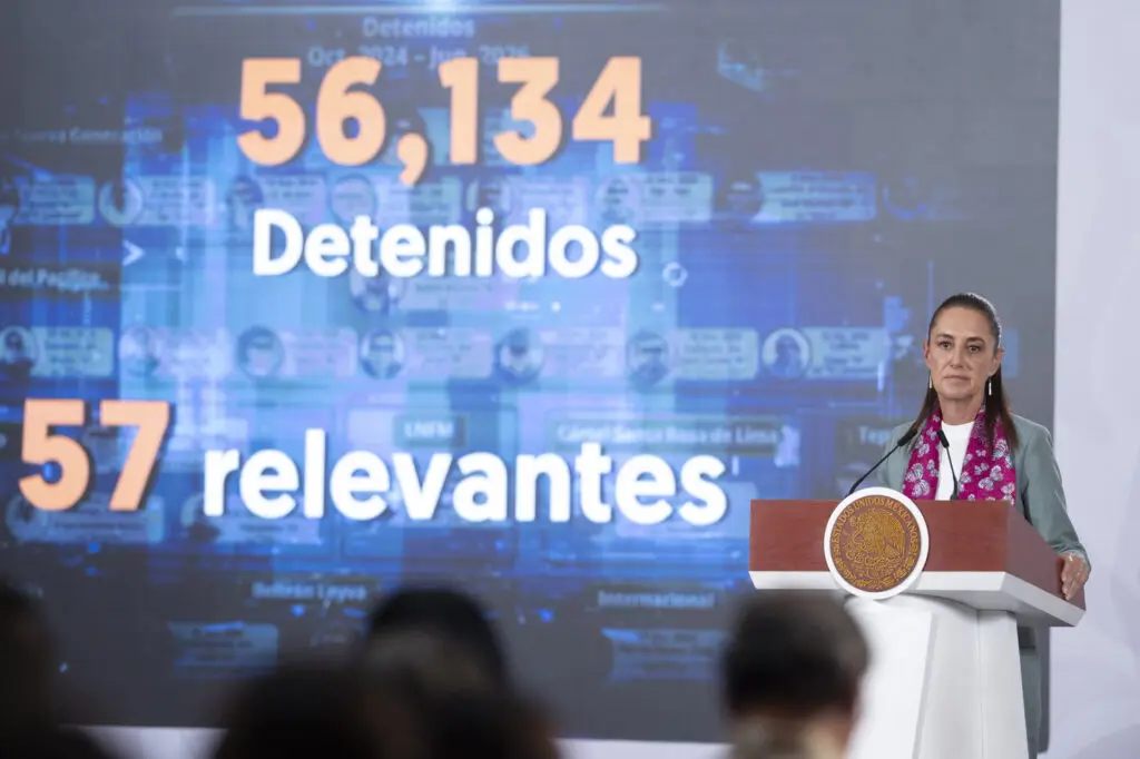 Woman at podium with projected detention statistics