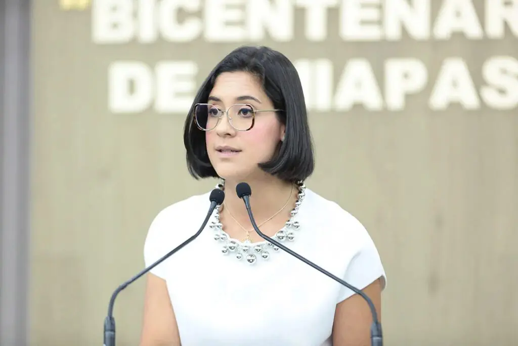 Woman with glasses speaking at podium