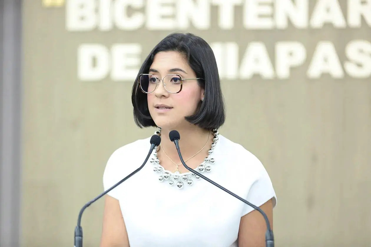 Woman with glasses speaking at podium