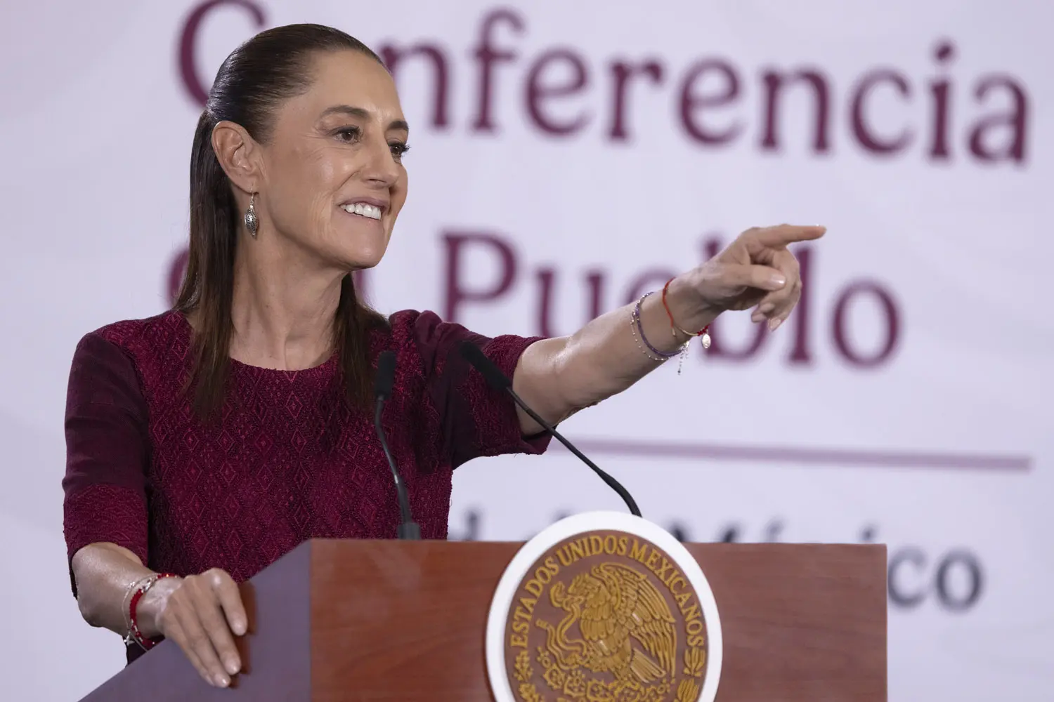 Smiling speaker pointing toward audience