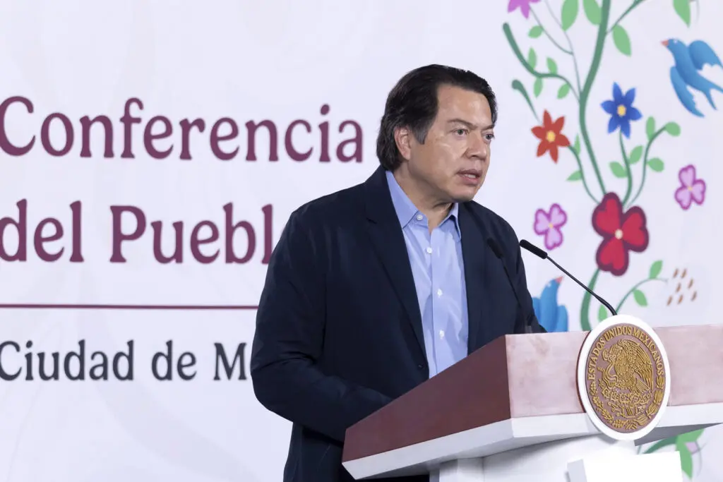 Man speaking at podium with floral backdrop