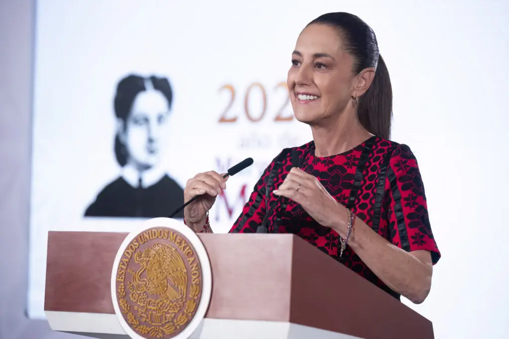 Smiling woman giving speech at podium with seal