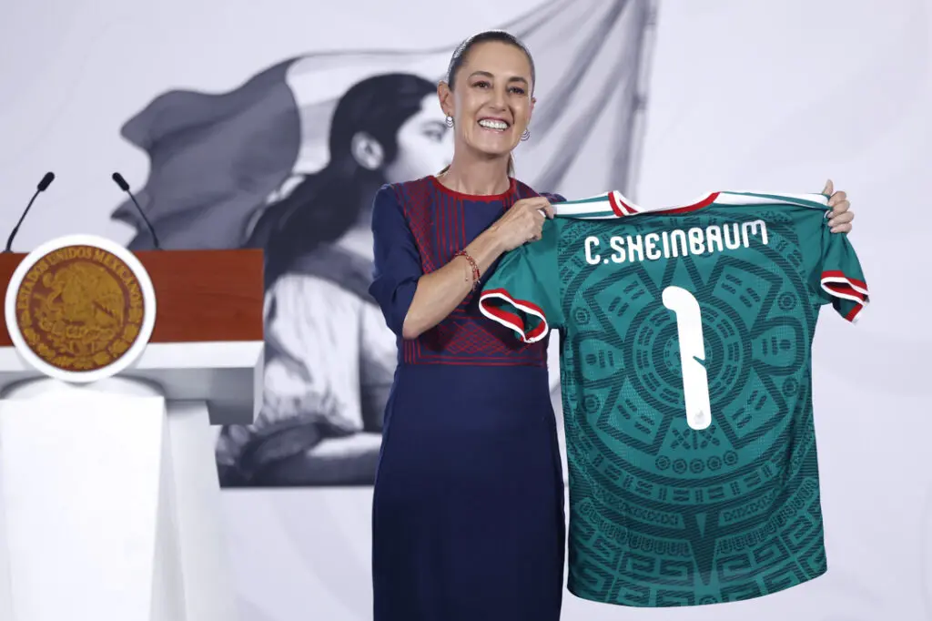 Smiling woman holding green soccer jersey