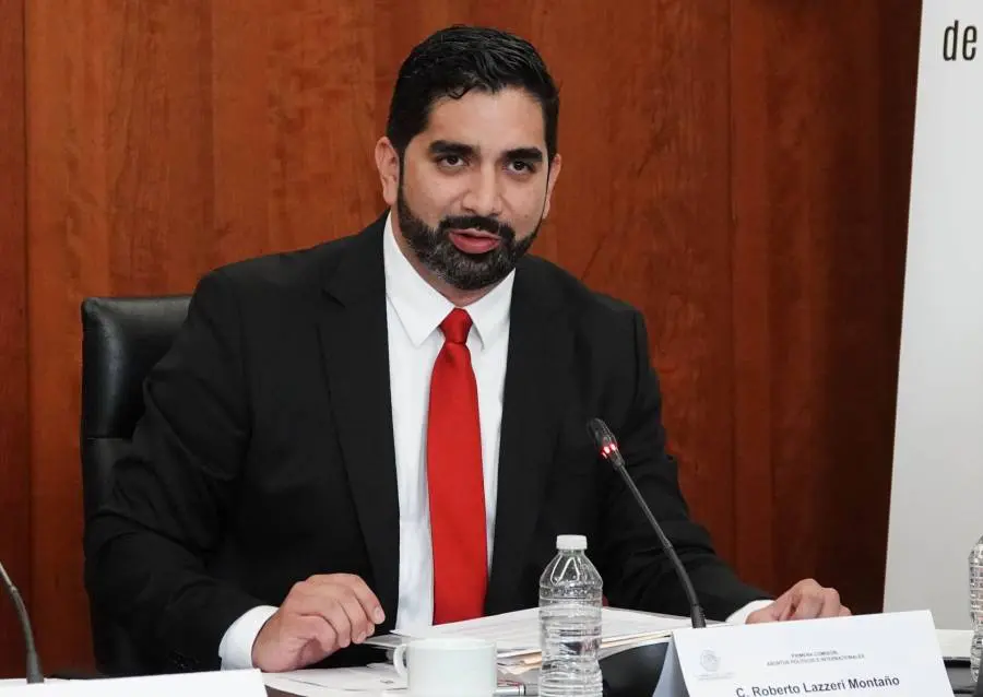 Bearded man in suit speaking at conference table