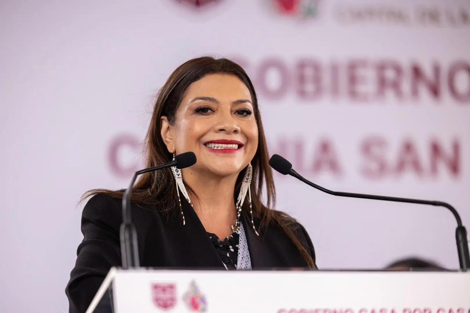 Woman smiling while speaking behind a podium