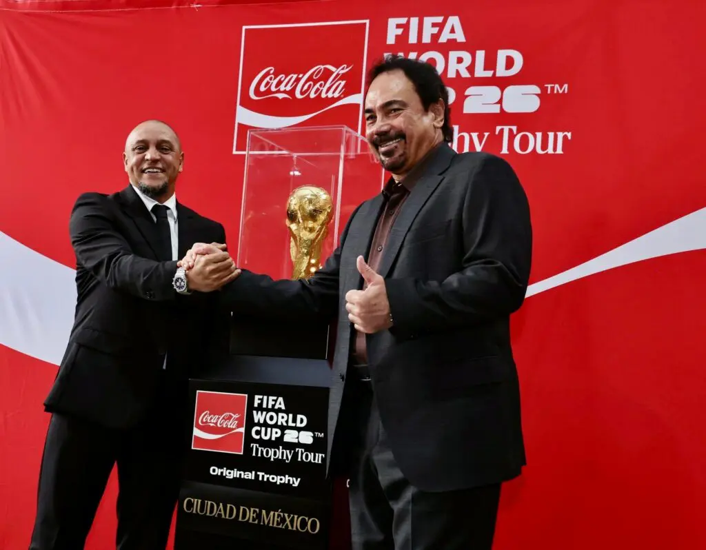 Two men posing with FIFA World Cup trophy