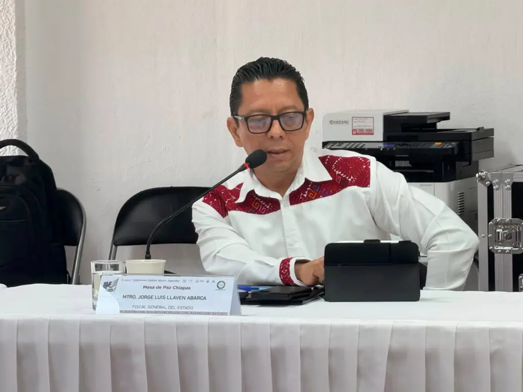 Man speaking into microphone at meeting table