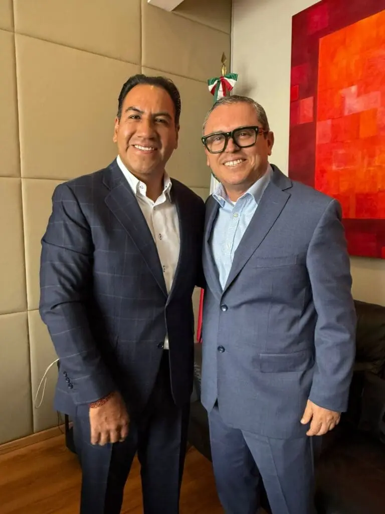 Two smiling men in suits posing together