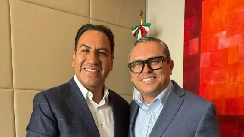 Two smiling men in suits posing together