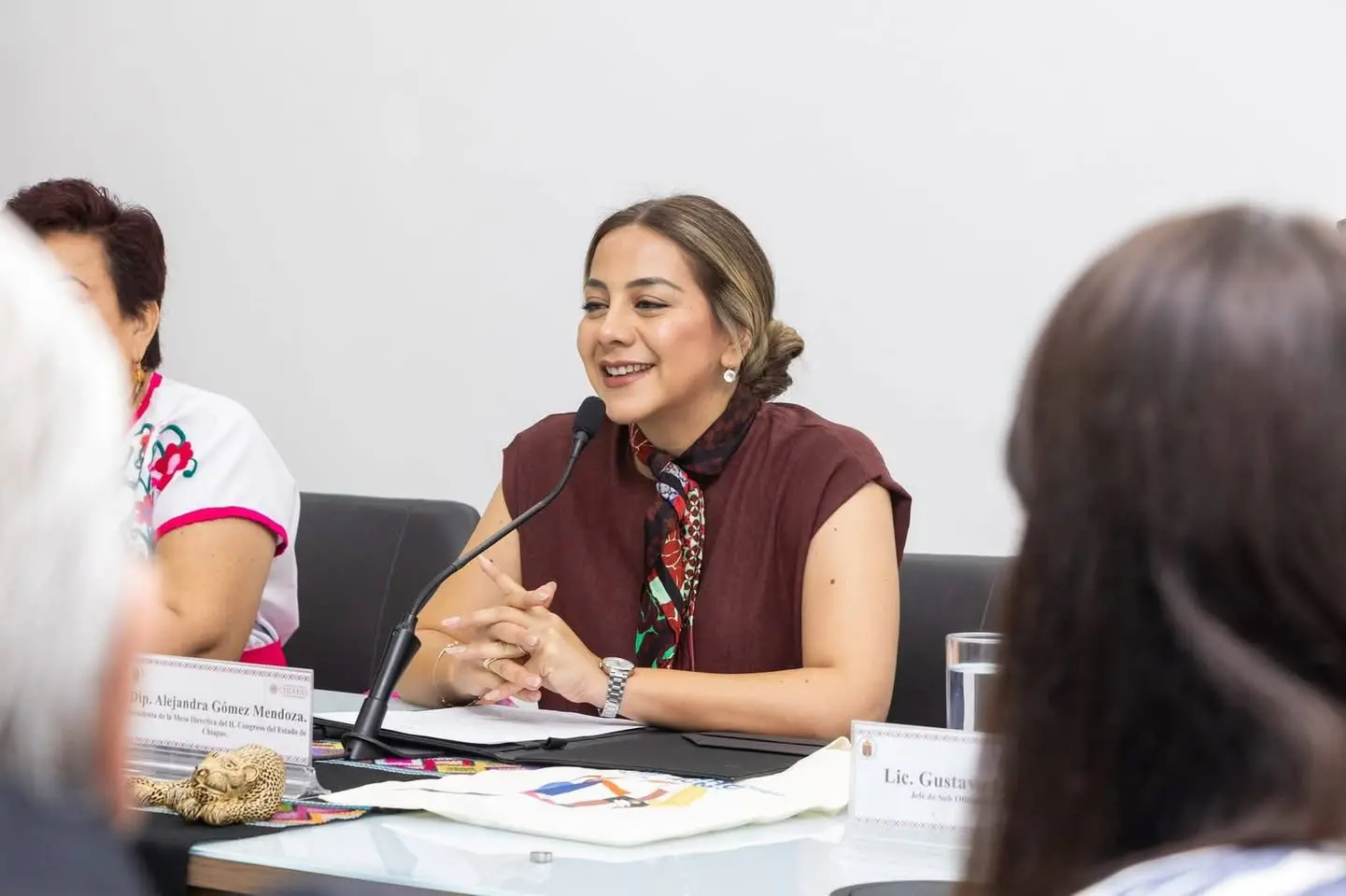 Smiling woman speaking at conference table
