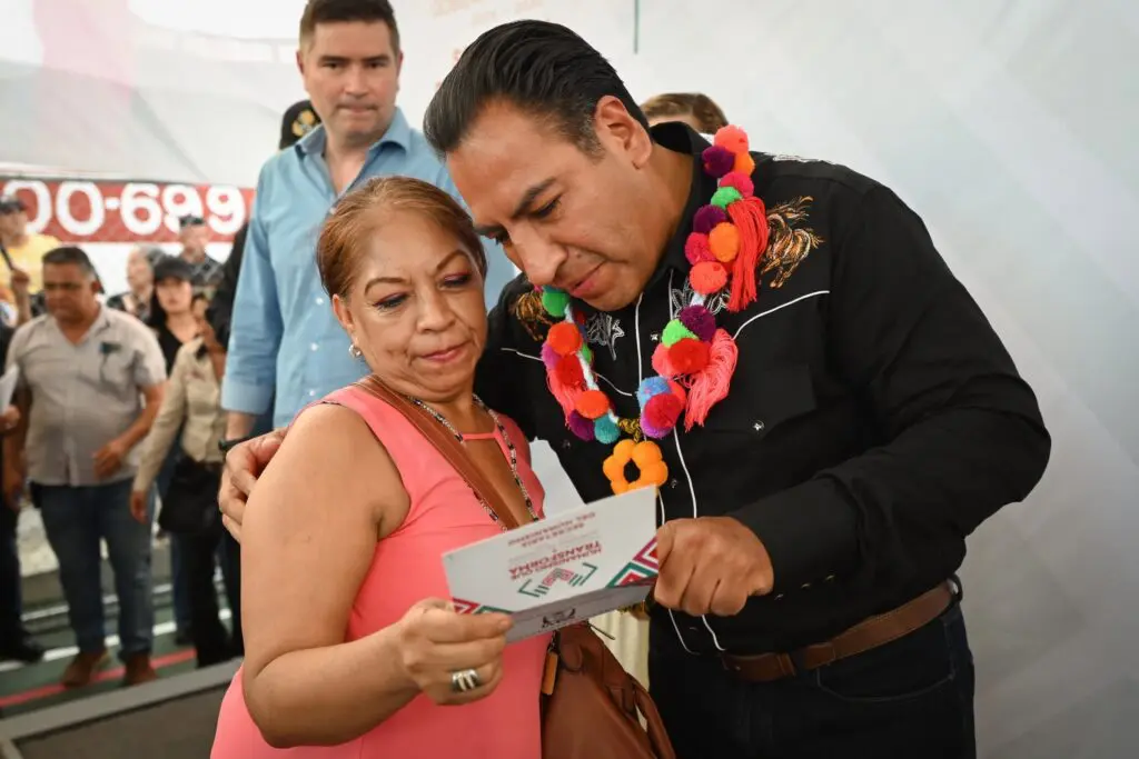 Man with floral garland reads pamphlet with woman