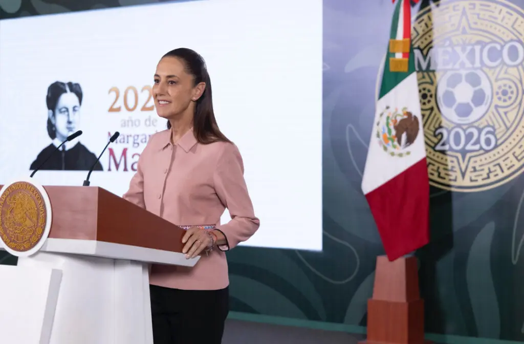 Woman in pink jacket speaking at lectern
