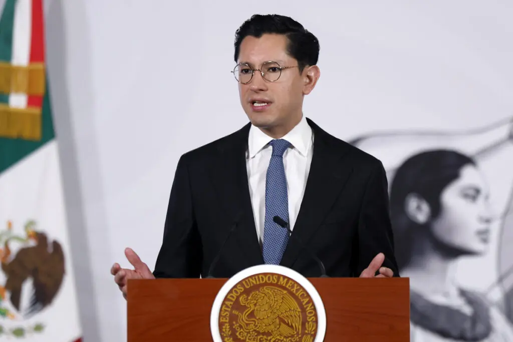 Politician speaking at podium with Mexican seal