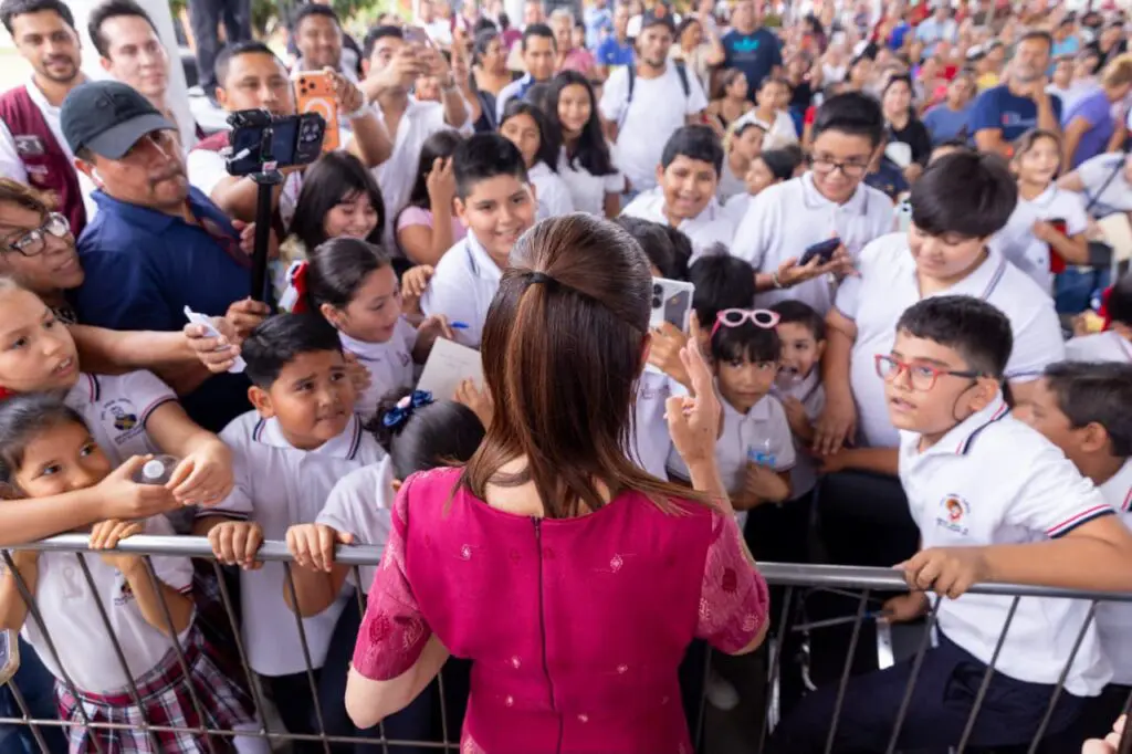 Woman taking photo with excited schoolchildren