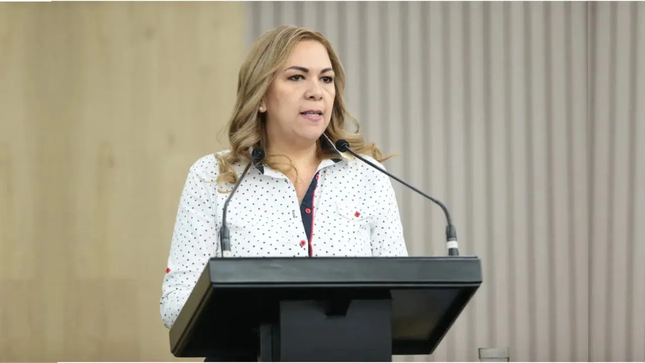 Blonde woman speaking behind black lectern