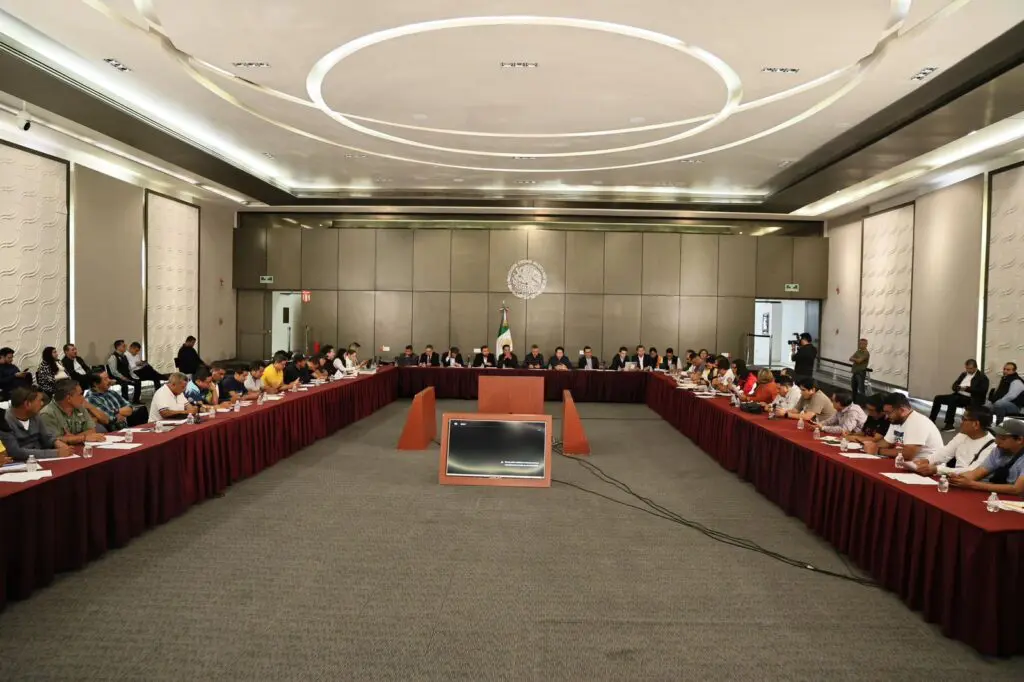 Large conference with delegates seated around U-shaped table
