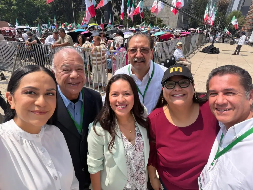 Group selfie of six smiling people at rally