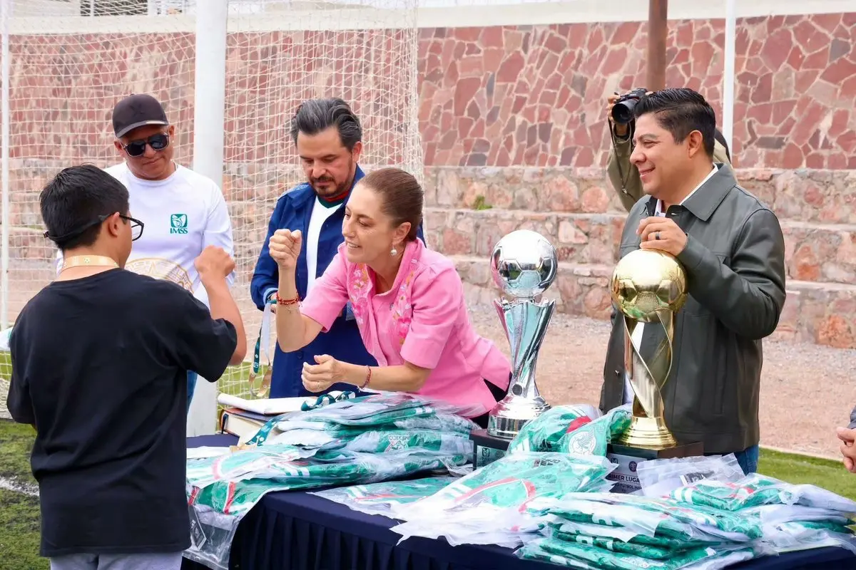 Officials presenting trophies and jerseys to child