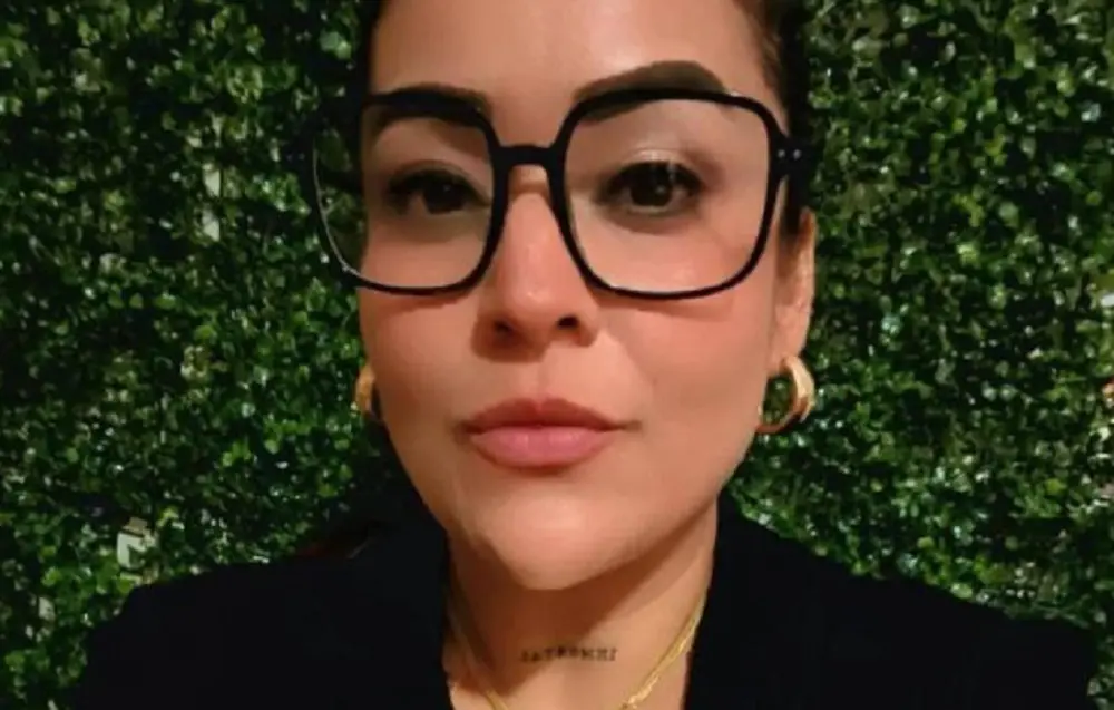Woman wearing large glasses with leafy background