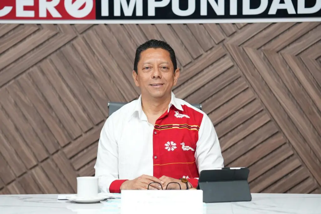 Man in white and red shirt at desk
