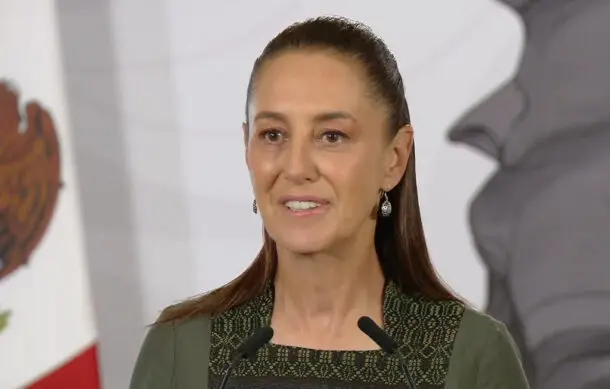 Woman addressing audience with flag backdrop