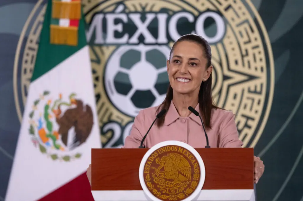 Woman smiling at podium with Mexican emblem