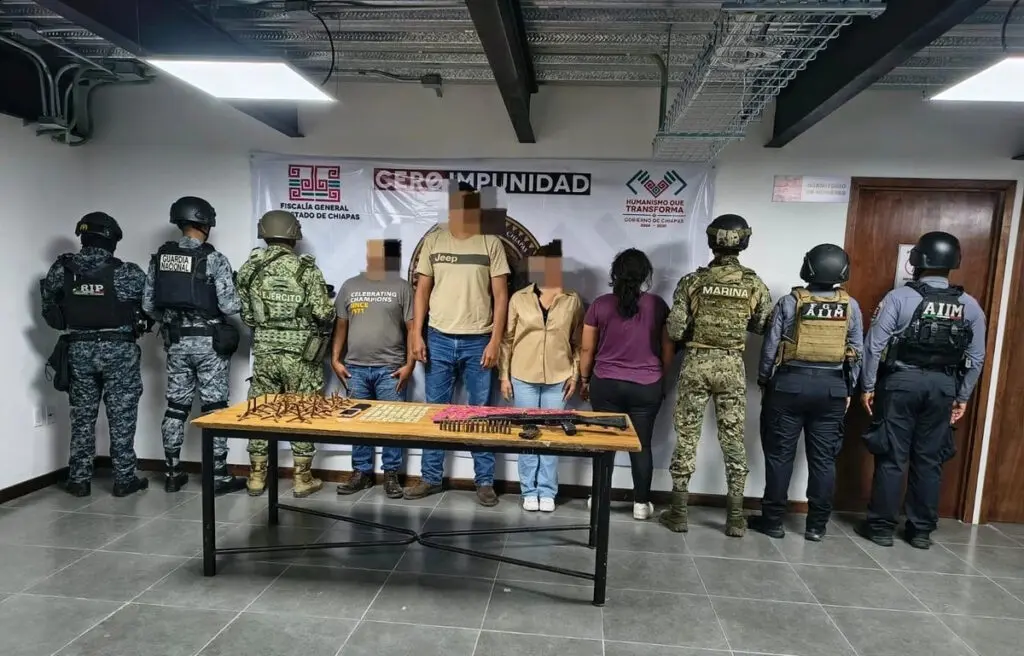 Detainees stand with weapons and uniformed officers
