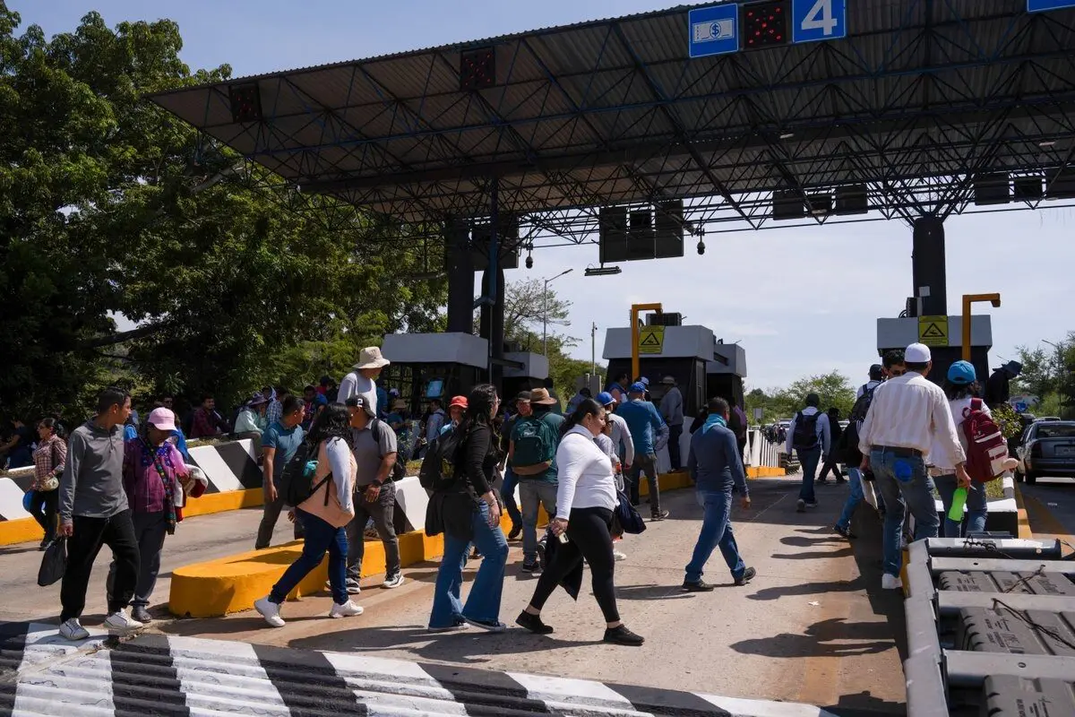 Group of pedestrians crossing toll booth lanes