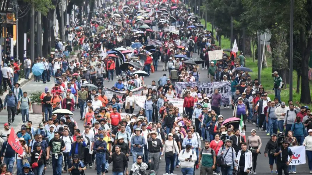 Mass street protest with banners and umbrellas