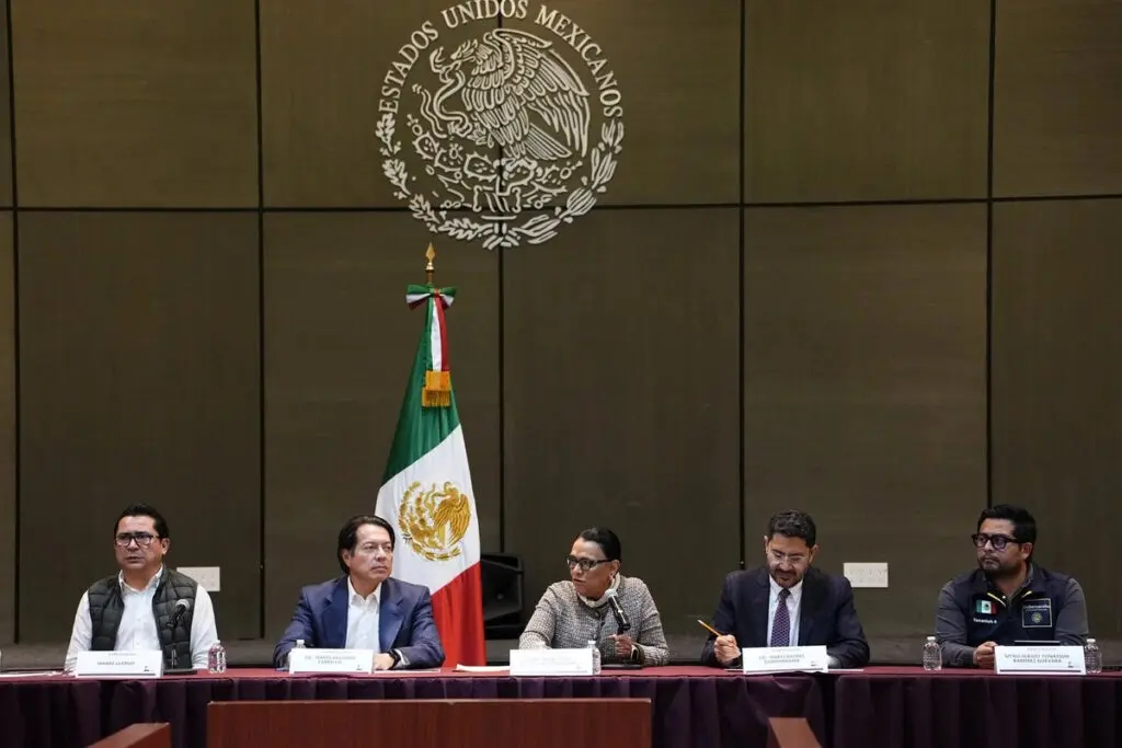 Panel discussion with Mexican flag and emblem