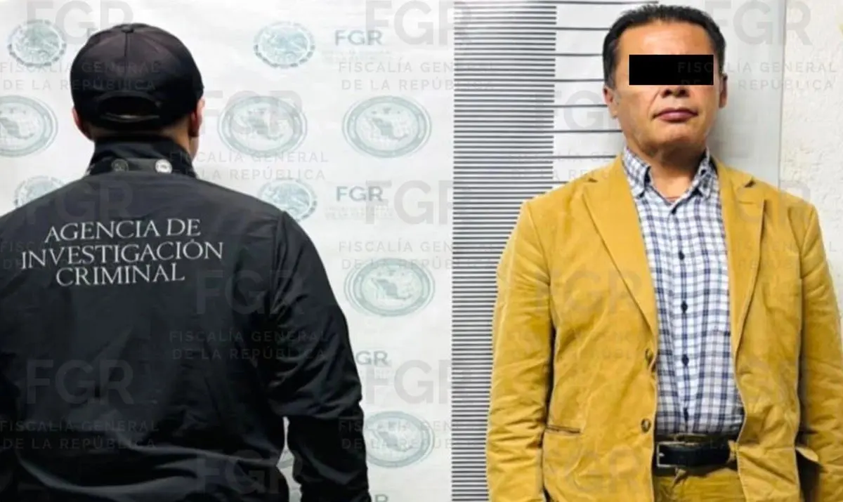 Man with black bar over eyes beside investigator